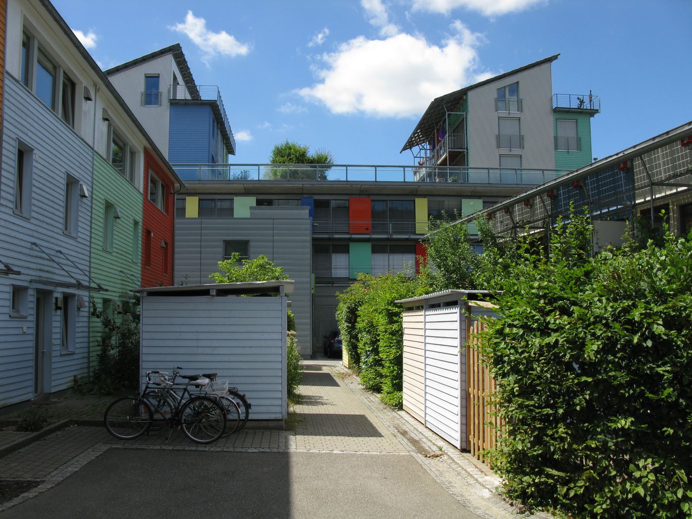 Rows of terraced houses with solar panels on the roofs in the Solarsiedlung, with a large solar-roofed building behind
