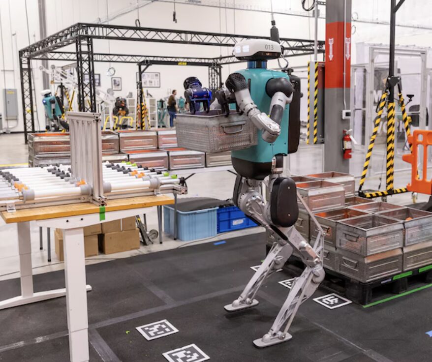A Digit humanoid robot carrying a tote inside Agility Robotics' Salem factory